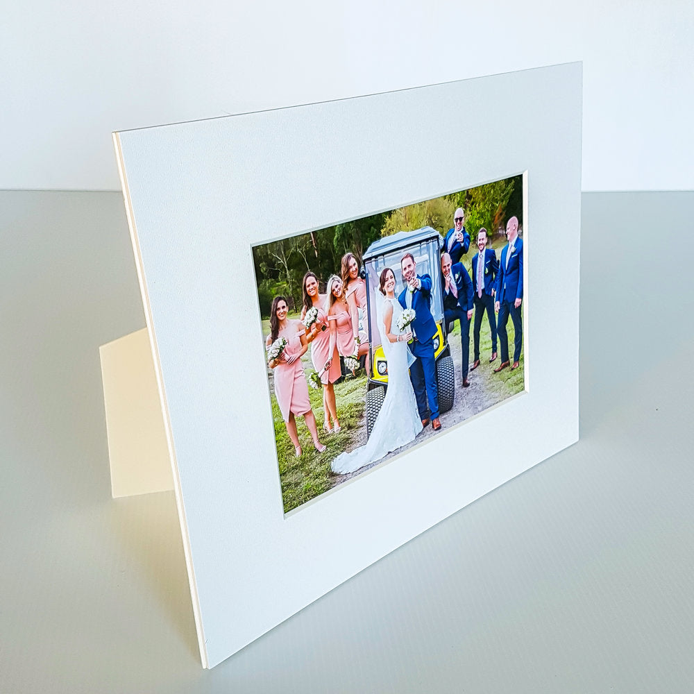 Each mount has its own built in stand on the back. Simply fold it out, click it in to place, and stand it up in a vertical OR horizontal position. Prints easily slide through a space at the side of the mount.