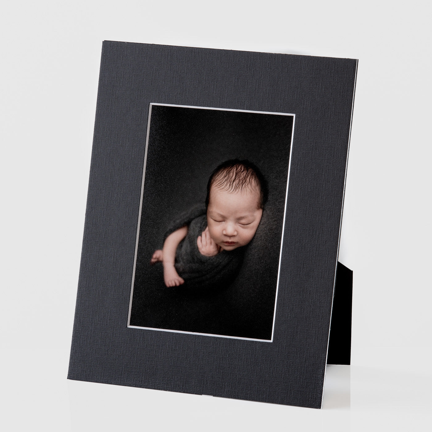 Each mount has its own built in stand on the back. Simply fold it out, click it in to place, and stand it up in a vertical OR horizontal position. Prints easily slide through a space at the side of the mount.