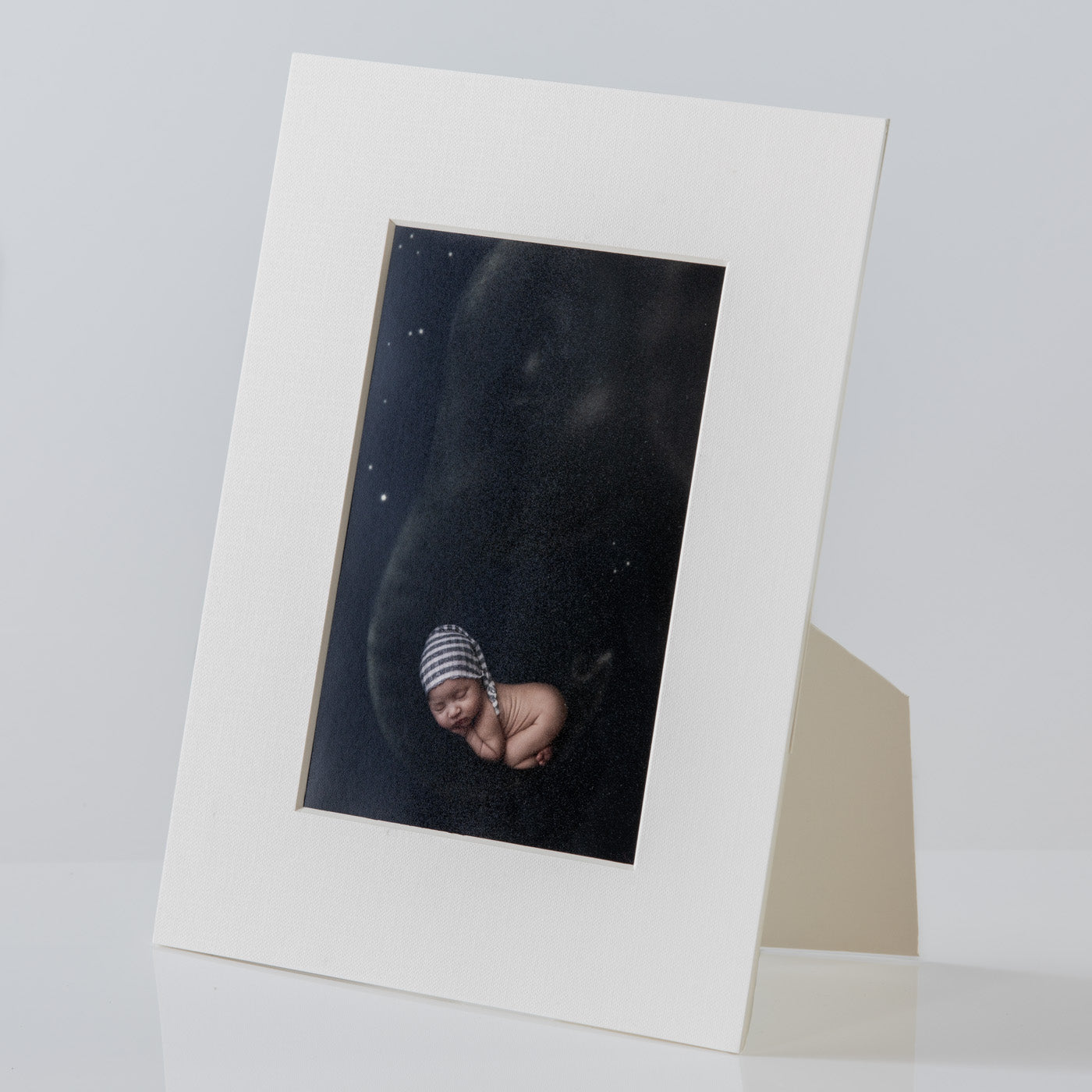 Each mount has its own built in stand on the back. Simply fold it out, click it in to place, and stand it up in a vertical OR horizontal position. Prints easily slide through a space at the side of the mount.