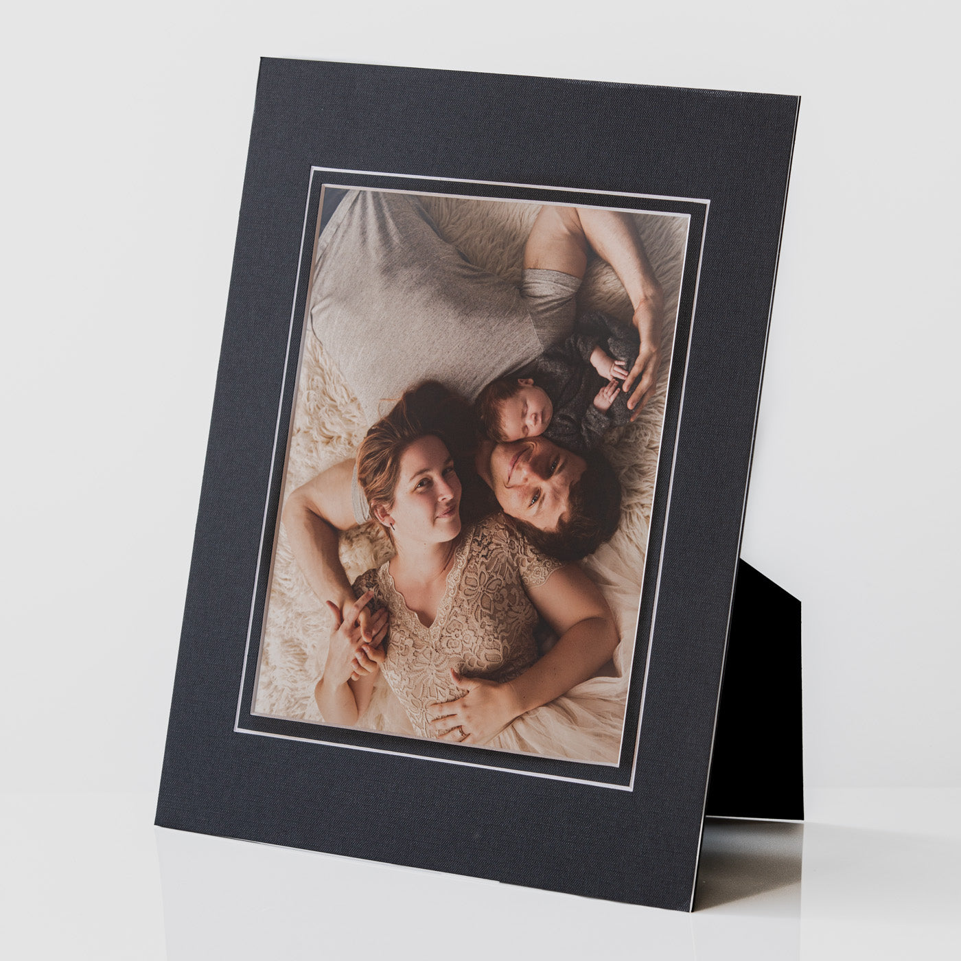 Each mount has its own built in stand on the back. Simply fold it out, click it in to place, and stand it up in a vertical OR horizontal position. Prints easily slide through a space at the side of the mount.