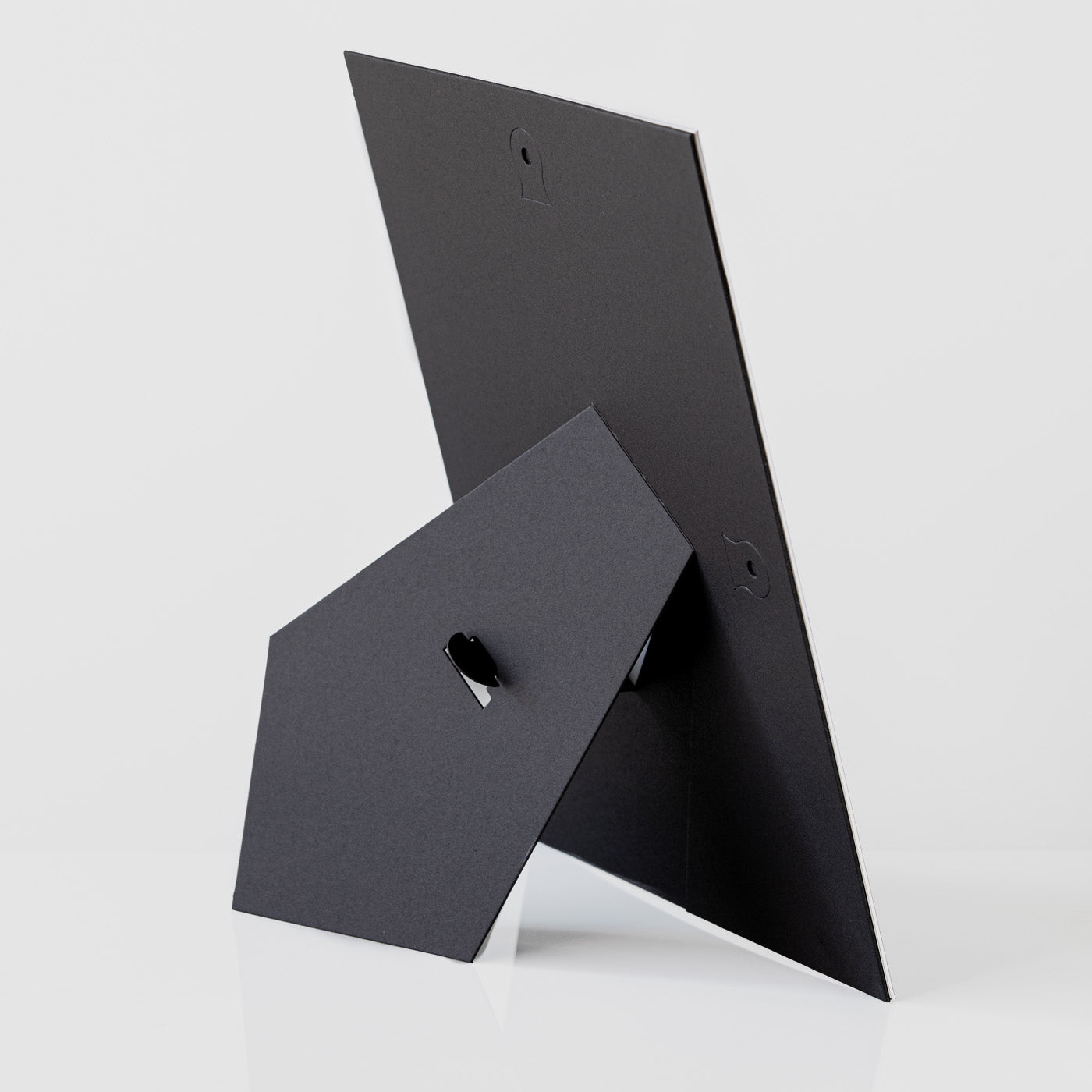 Each mount has its own built in stand on the back. Simply fold it out, click it in to place, and stand it up in a vertical OR horizontal position. Prints easily slide through a space at the side of the mount.