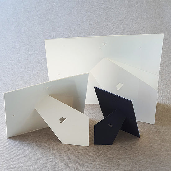 Each mount has its own built in stand on the back. Simply fold it out, click it in to place, and stand it up in a vertical OR horizontal position. Prints easily slide through a space at the side of the mount.